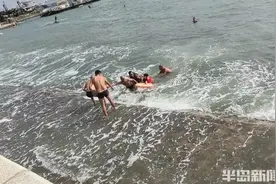 青岛海边惊险一幕！父子俩游泳突遇大浪被困海里，危急时刻……图片