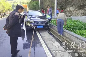 车辆“失足”陷边沟 保康警民合力抬车施救图片
