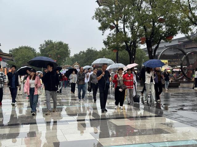 漫步不夜城 雨天游客热情不减