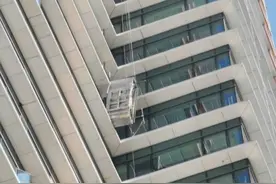 高空作业发生意外，吊篮垂直倾斜，两工人被挂空中……图片