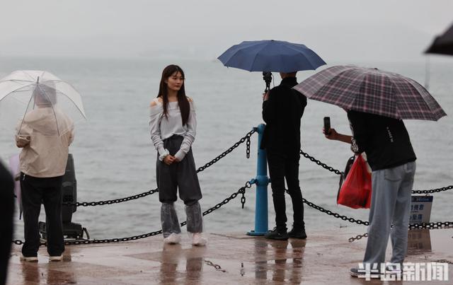 秋雨润栈桥，伞海映人潮