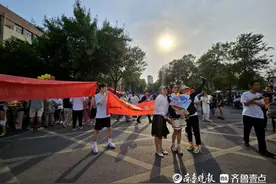 小伙子举横幅，庆祝朋友高考结束图片