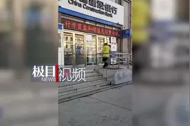 大连一女子捡石头砸裂银行玻璃门，民警现场将她控制图片