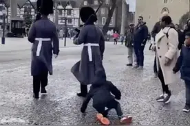 嫌小男孩挡道，英国女王卫队士兵直接从他身上踩了过去图片