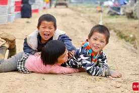 收获时节，以菜田为家，年轻的爸爸在地里为孩子换尿片图片