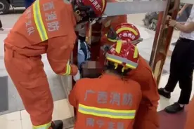 南宁一“熊孩子”将头钻到两扇玻璃门之间玩耍，不料颈部被卡住图片