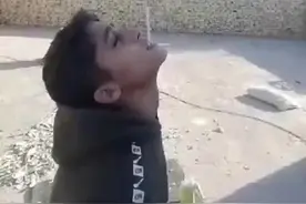 炫耀枪法？伊拉克一父亲竟让儿子嘴叼烟抬头当“靶子”，拿起AK-47朝烟射击图片