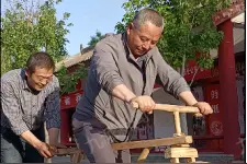 甘肃一木匠纯手工打造木制自行车：连杆驱动运转，骑车时后面要人扶着图片