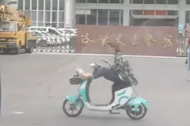 女子玩手机双脚搭在电动车车头，淡定通过交警门口，洛阳交警回应图片