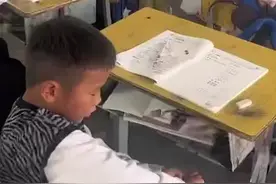 一年级男孩脱鞋手脚并用做算术题 算完还不忘把鞋子穿上图片