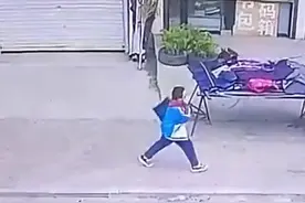 小男孩捡起地上国旗 拍去尘土带回家图片