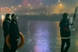 小伙站在结冰的河面上放烟花，警察叔叔拿着救生圈身后默默守护图片