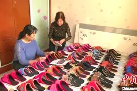 传承传统技艺 新疆女子14年一针一线手工绣布拖鞋图片