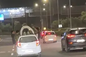 印度男子爬上车顶做俯卧撑：车辆快速行驶，多人探出身子围观图片