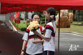 没有参加高考的她，“蹲守”在考点外为同学们送上一朵鲜花图片