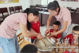 襄城区卧龙中心幼儿园：萌娃进社区 包粽迎端午图片