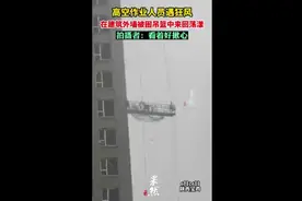高空作业人员遇狂风，在建筑外墙被困吊篮中来回荡漾图片