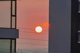 站在窗边看日出，太阳缓缓升起图片