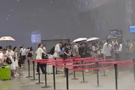 绍兴北站候车厅漏雨变“水帘洞”，乘客撑伞过闸机乘车，该站曾因多次漏雨被吐槽图片