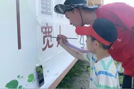 妙笔生花绘墙画 朱笔描红敬先烈图片