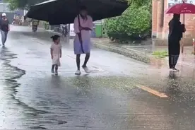 拍客｜雨天爸爸扛巨伞接女儿放学 网友：她的童年，我的梦想图片