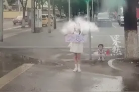 女孩雨天举感谢恩人牌子，送别救援队。视频来源：@新郑市泰山救援队—图片