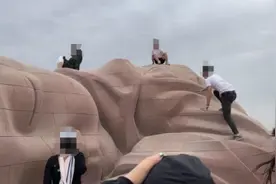 游客无视警示牌爬到“大地之子”雕塑上拍照，政府部门：将聘请志愿者维护秩序图片