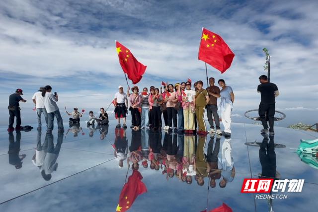 大美红图丨最爱中国红 游客在天空之镜舞动国旗