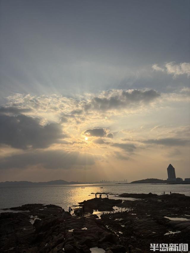 落日穿云洒海面，定格海滨温柔