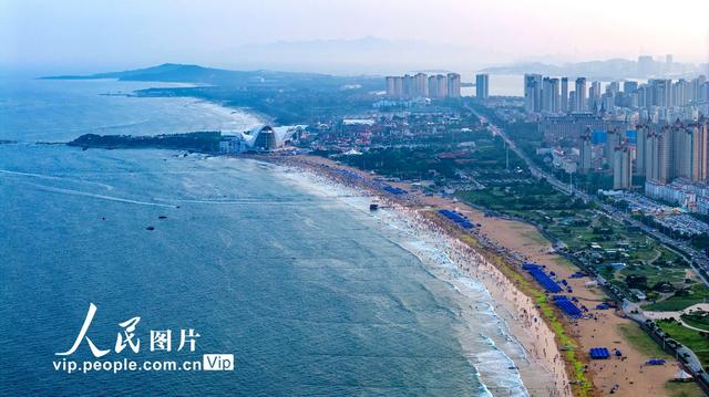 青岛金沙滩海滨开启“人从众”模式