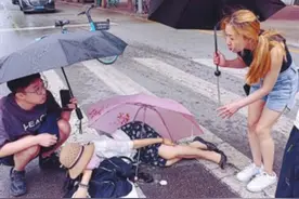 雨中一女子骑自行车摔伤 多位市民接力撑起爱心伞图片