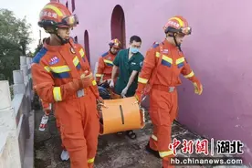 老人登山摔伤被困 消防员接力抬人下山图片