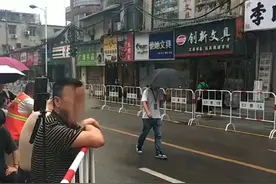 高考第二日湖南局地有雨，家长雨中撑伞送考，喊口号为考生送行图片