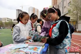 世界读书日 青海西宁小学生校园“跳蚤市场”淘书图片
