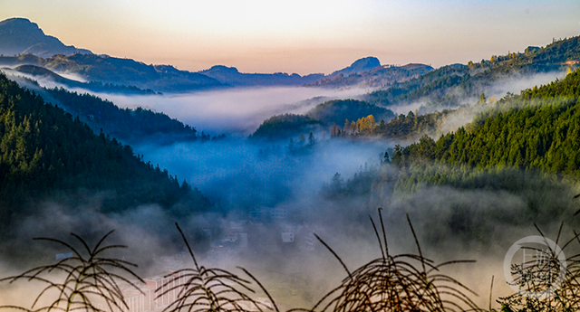 晨雾缭绕间，日出点亮山村