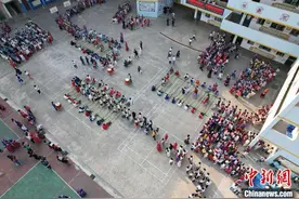 广西南宁小学生千人共跳《竹竿舞》喜迎“广西三月三”图片
