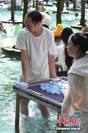成都高温天气持续 游客打水上麻将享清凉