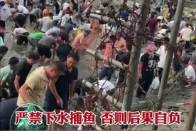 水库泄洪后村民冲破围栏抓鱼，不理会安全提醒和劝阻。拍摄者：之前有人摔伤过图片