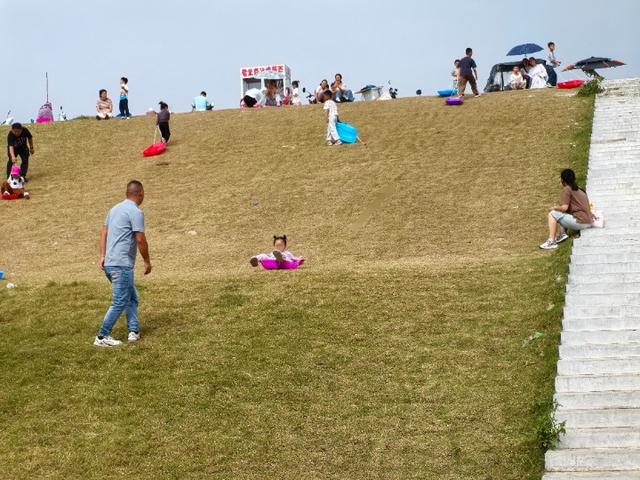 六安一处河堤草坡，国庆假期变成滑草乐园