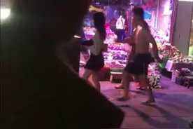 成都一男子半身赤裸，当街骚扰女子，小吃摊老板冲上一把将其推开。图片