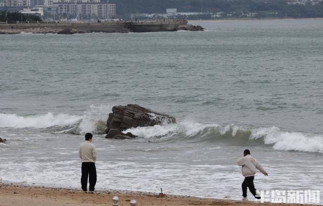 沿海迎大浪，游客沙滩驻足