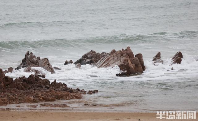 沿海迎大浪，游客沙滩驻足