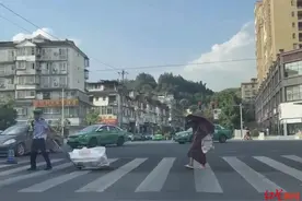 雅安街头暖心一幕：拾荒老奶奶艰难过街 00后辅警上前帮拖小车，带她过马路图片