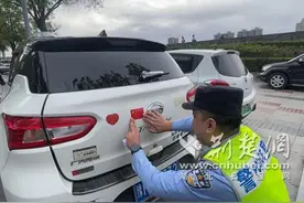 国庆节襄阳民警送惊喜 为路过的车辆贴上国旗反光贴图片
