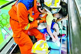 忙着“救”行李箱 男孩脚卡扶梯缝隙图片