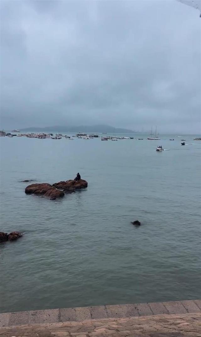 男子遇海水涨潮被困礁石淡定刷手机