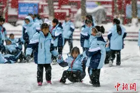 乌鲁木齐持续降雪 小学生雪中玩耍打雪仗图片
