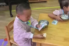 幼儿园入学第二天，宝宝看着妈妈照片边吃早饭边哭，又好笑又心疼图片