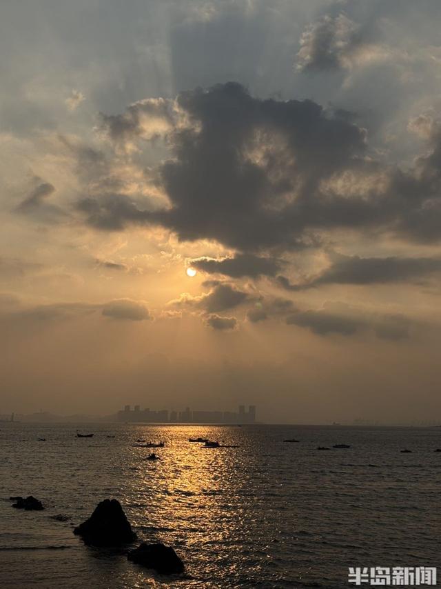 落日穿云洒海面，定格海滨温柔