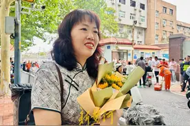 济南一家长穿旗袍捧向日葵送考，“昨天彩票中了10元，是个好兆头”图片